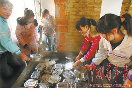 中午,列宁小学的学生们在学校伙房寻找自己蒸饭的饭盒.